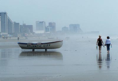 Atlantic City Lifeboat pictured with people walking on beach on a misty morning.